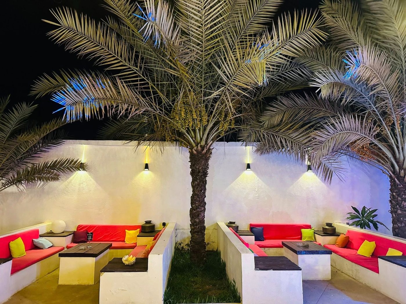 Terrasse tropicale de nuit avec coussins colorés et palmiers à L'Étoile de Mer Toliara